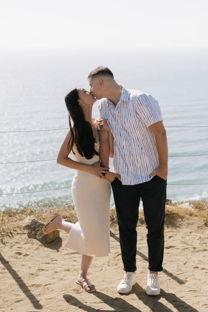 newly engaged couple kissing during their engagement photoshoot at Guy Fleming Trail