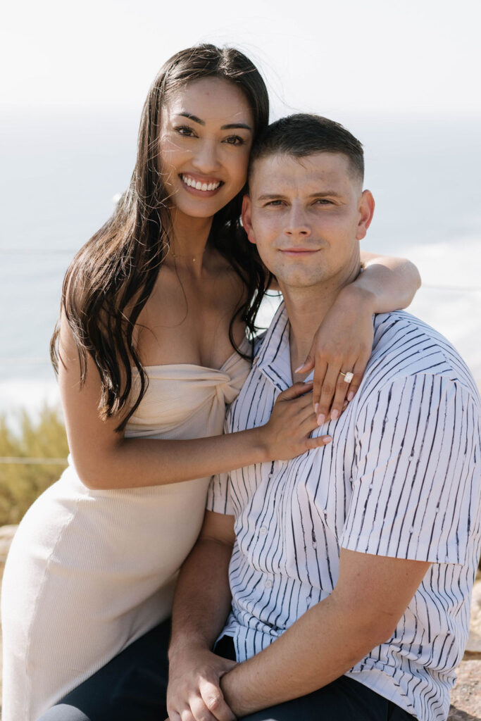 newly engaged couple looking at the camera during their engagement session at Guy Fleming Trail