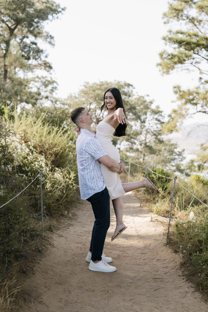 newly engaged couple showing their engagement ring at Guy Fleming Trail