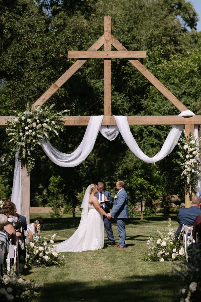 bride and groom holding hands at their wedding ceremony 