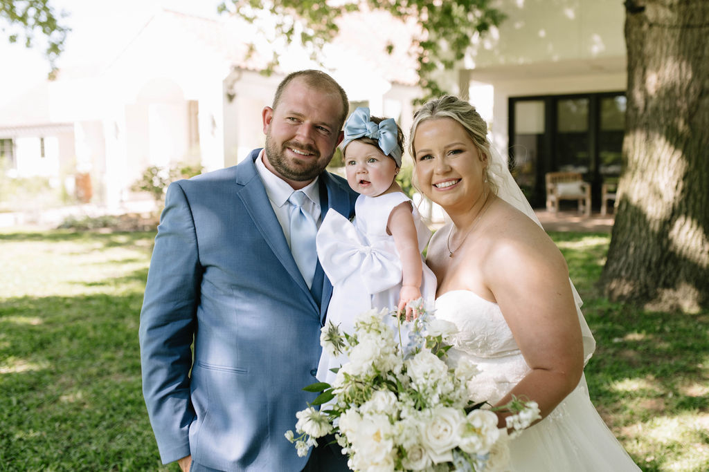 portrait if the bride and groom with their daughter