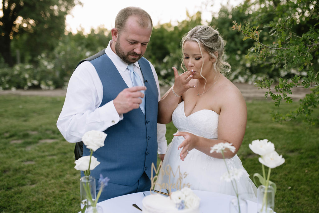 bride and groom trying their wedding cake