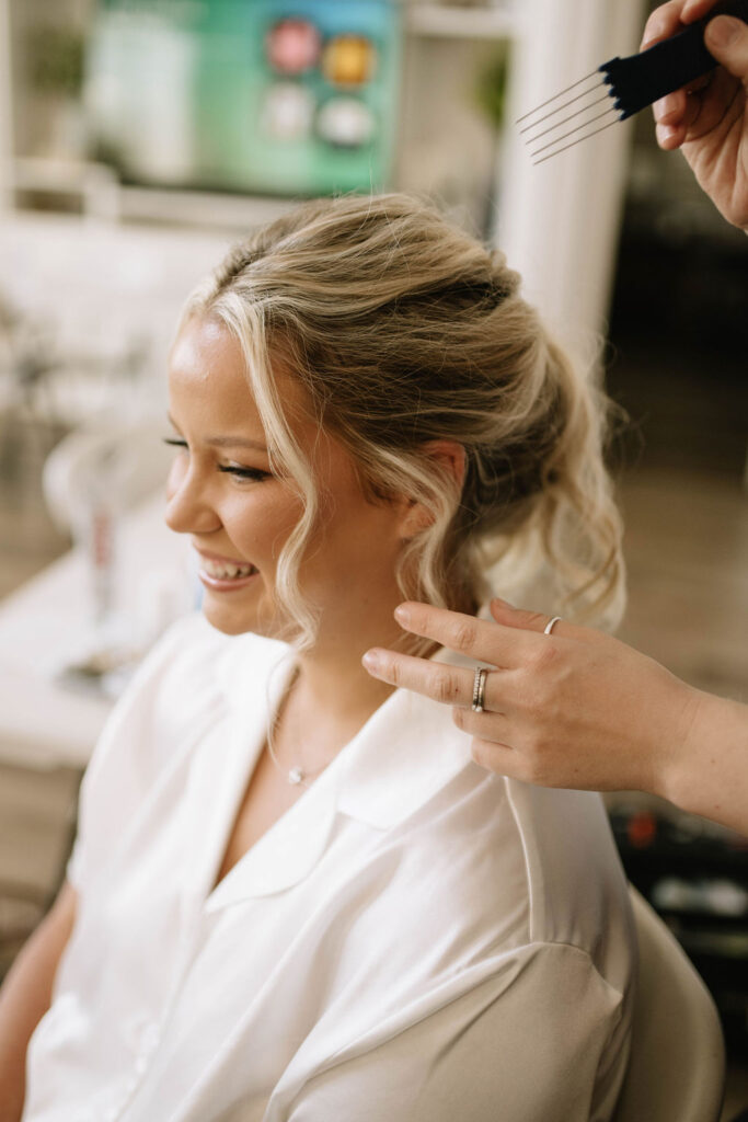 bride getting her hair done for her intimate garden wedding ceremony