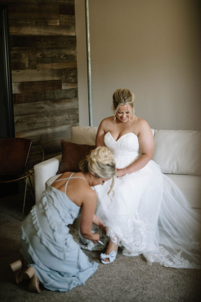 bridesmaids helping the bride with her wedding shoes 